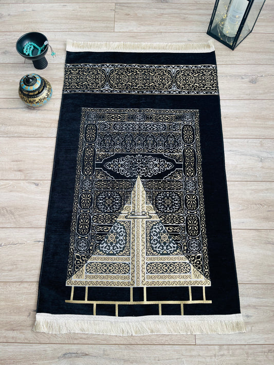 Black Islamic prayer mat featuring the sacred Kaaba in Mecca, symbolizing devotion and spiritual connection